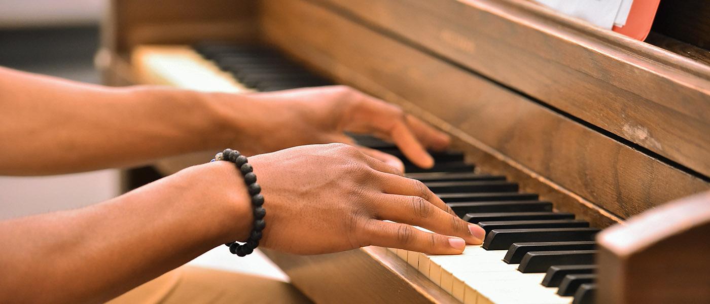 Close up of music student's hands playing the piano