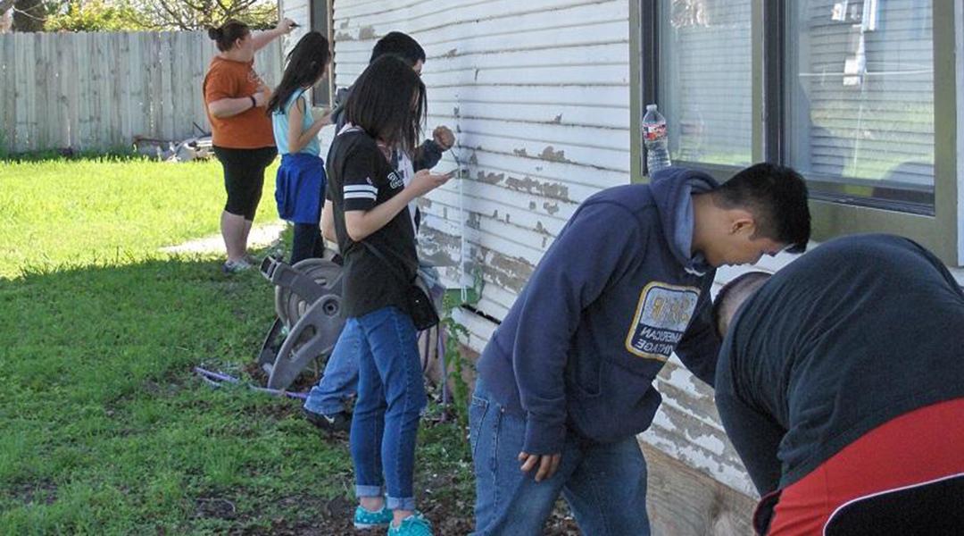 Students painting a house