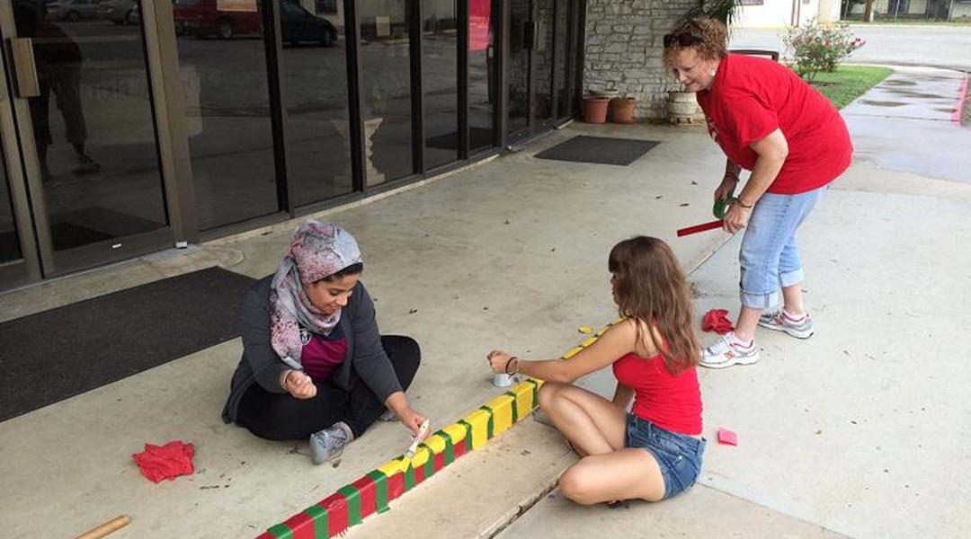 Students painting a sidewalk