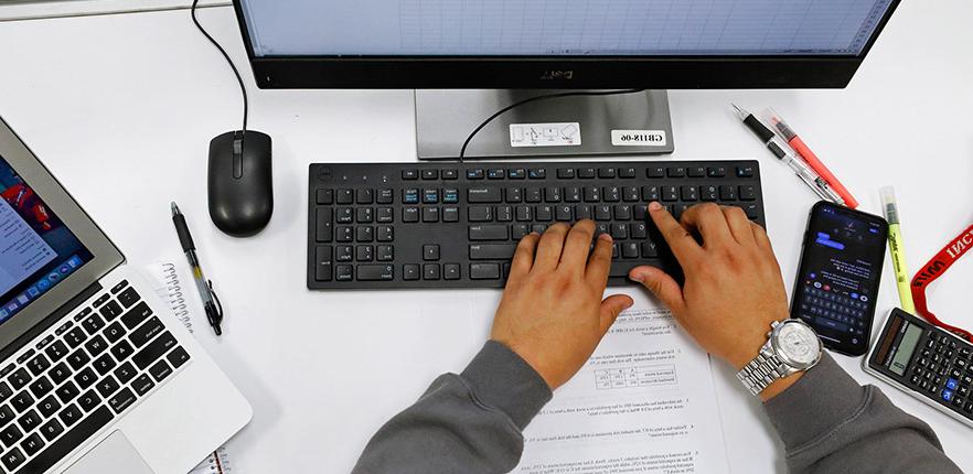 Student studying accounting with computer and calculator