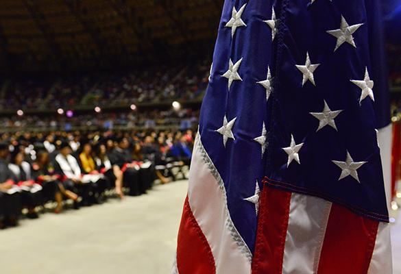 American flag with UIW graduates in the background