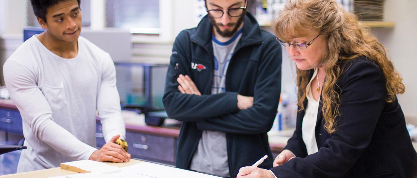 Interior design professor going over blueprints with her students