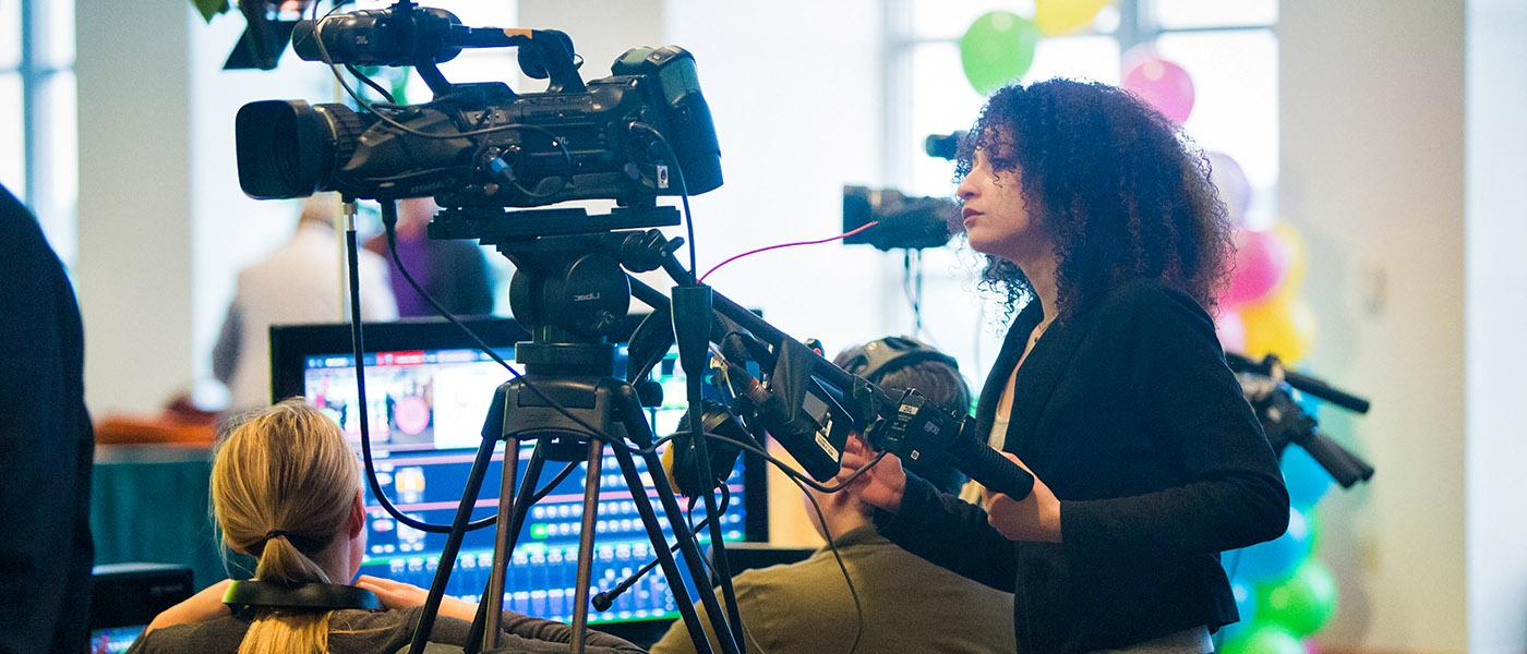 Student operating a TV camera during a broadcast production